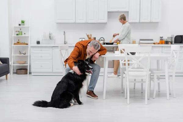 Medelålders Man Petting Gränsen Collie Nära Kaffekopp Köket — Stockfoto