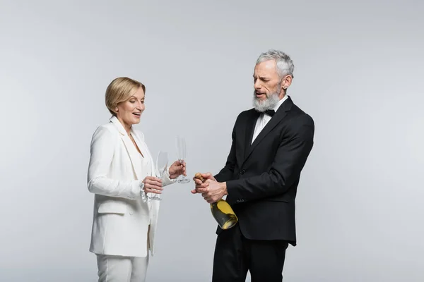 Gammal Brudgum Öppnar Champagne Nära Positiv Brud Med Glasögon Isolerade — Stockfoto