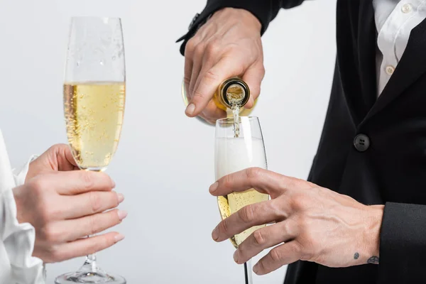 Обрезанный Вид Жениха Наливающего Шампанское Рядом Невестой Стаканом Изолированным Сером — стоковое фото