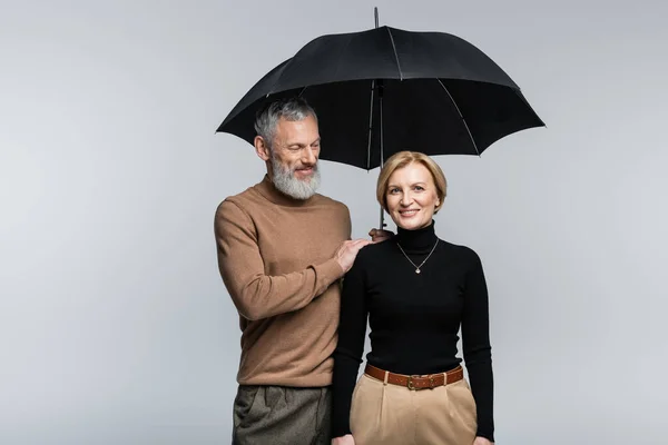 Stijlvolle Man Houdt Paraplu Boven Glimlachende Vrouw Geïsoleerd Grijs — Stockfoto