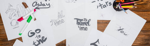 верхний вид белой бумаги с различными шрифтами возле войлочных ручек и цветных карандашей на деревянном столе, баннер