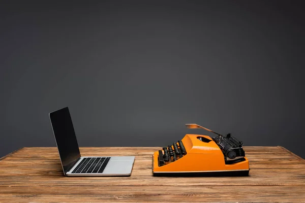 Bærbar Datamaskin Med Blank Skjerm Nær Skrivemaskin Skrivebord Tre Isolert – stockfoto