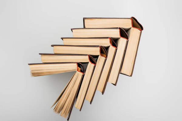 верхний вид открытых бумажных книг на светло-сером фоне