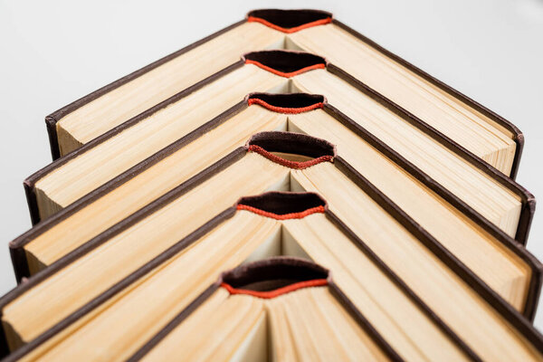 крупный план нескольких открытых книг, изолированных на светло-сером фоне