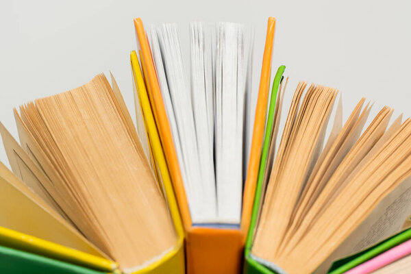 close up of books with colorful covers isolated on grey, top view