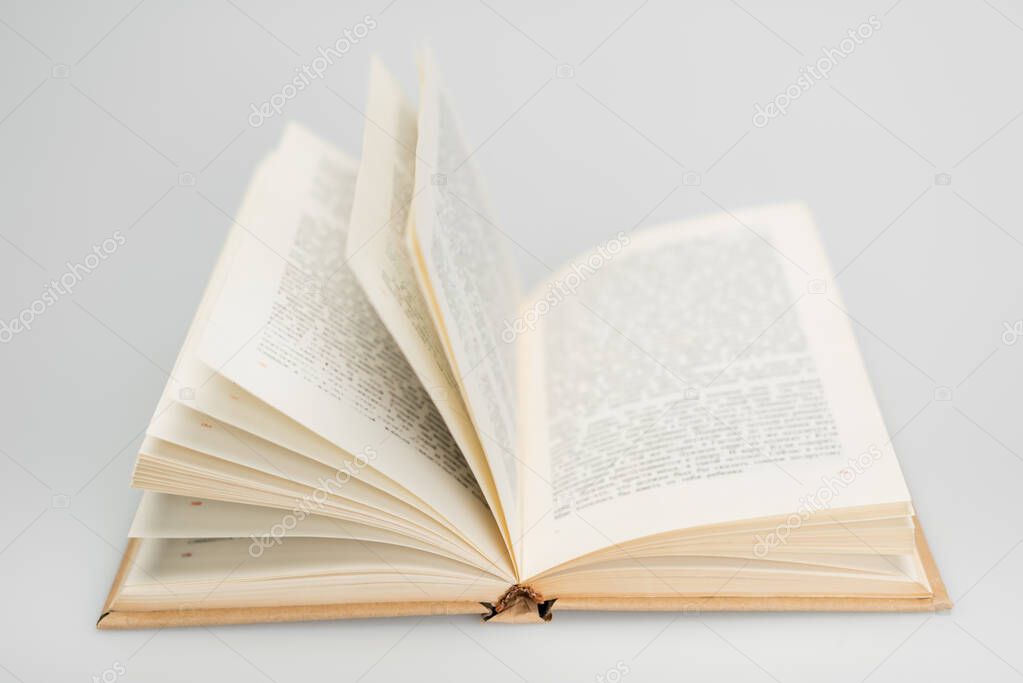 open book with text on grey blurred background