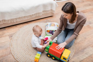 Anne ve bebeğin evdeki yapı taşlarıyla oynamalarının genel görünümü 