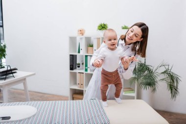 Klinikteki bebek çocuğa bakan pozitif aile doktoru. 