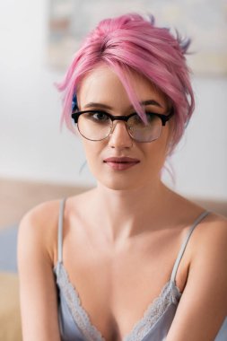 Kameraya bakan boyalı saçlı genç bir kadının portresi.