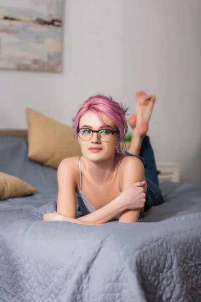 안경테를 분홍색 머리의 여자가 침대에 — 스톡 사진