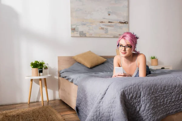 Mujer Joven Soñadora Con Pelo Teñido Acostado Cama Mientras Sostiene — Foto de Stock