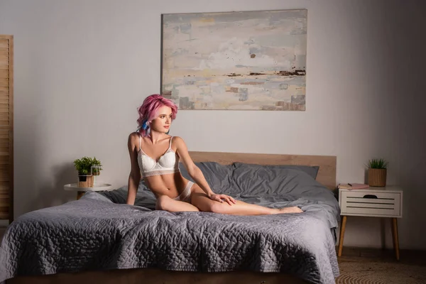 穿着性感内裤坐在床上的迷人的年轻女人 — 图库照片