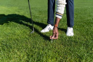Afrika kökenli Amerikalı son sınıf öğrencisinin yeşil çimlere golf sopası koyması...