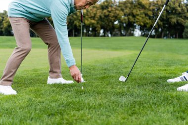 Asyalı son sınıf öğrencisi golf tişörtünü takıyor. 