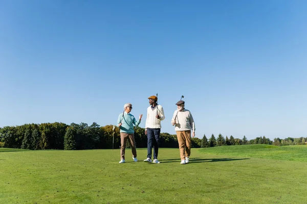 Idősebb Fajok Közötti Barátok Séta Golf Klubok Pályán — Stock Fotó