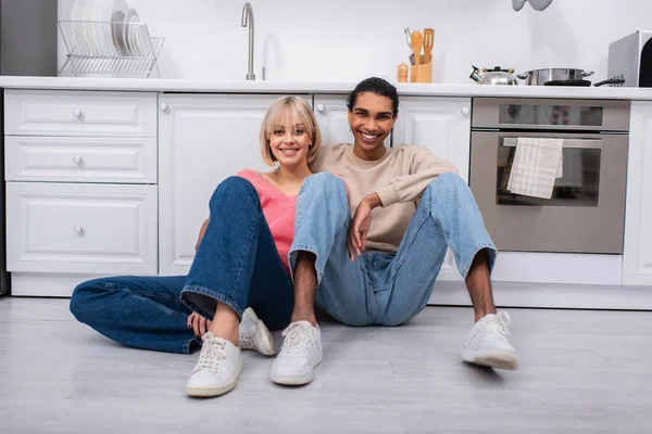 Positive Multiethnic Couple Sitting Floor Modern Kitchen — Stock Fotó