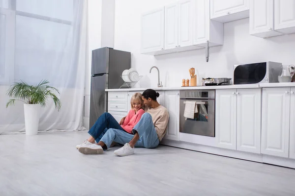 Joyful Multiethnic Couple Sitting Floor Modern Kitchen — Stock fotografie