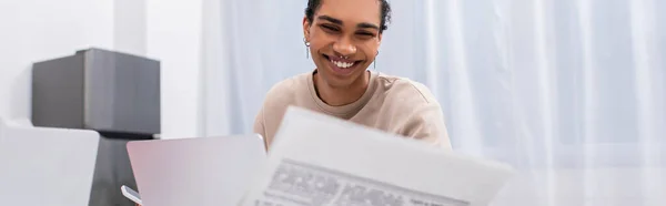 快乐的年轻非洲裔美国人 在笔记本电脑旁阅读报纸 高举横幅 — 图库照片