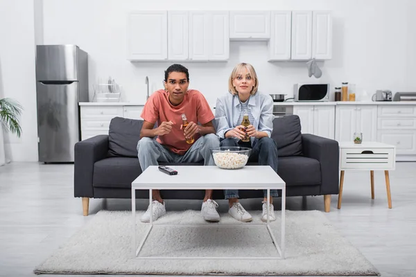Young Multiethnic Couple Cheering While Watching Sport Match Living Room — Fotografia de Stock
