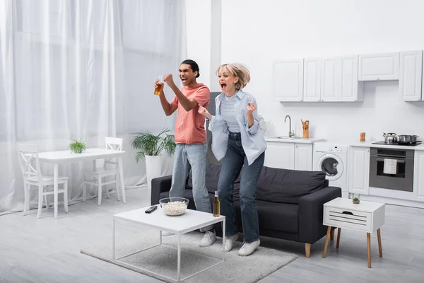 Excited Interracial Couple Jumping While Watching Sport Match Living Room — Photo