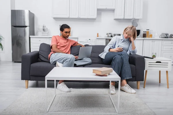 Freelancer Afroamericano Usando Laptop Cerca Novia Con Smartphone Sentado Sofá — Foto de Stock