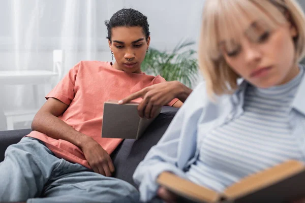 Young African American Man Reading Book Blurred Blonde Woman — Stock fotografie