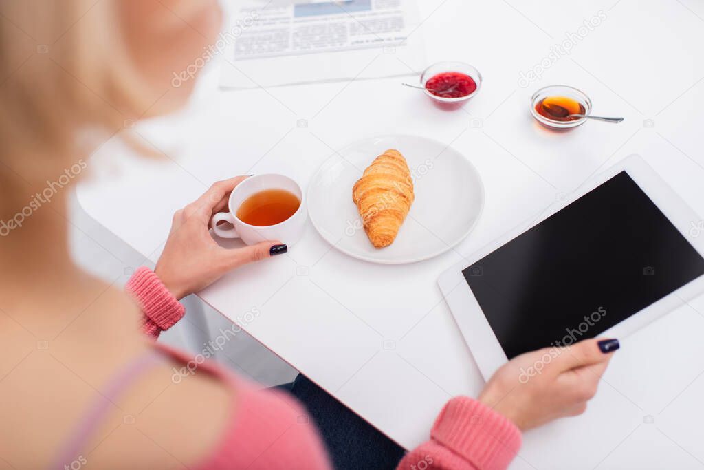 high angle view of woman using digital tablet during breakfast 