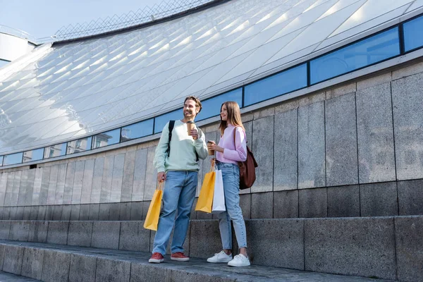 Positive Couple Holding Paper Cups Shopping Bags Building Outdoors — Stock Photo, Image