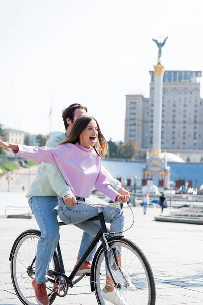 КИЕВ, УКРАИНА - 1 СЕНТЯБРЯ 2021: Возбужденная женщина на велосипеде с парнем на Майдане Независимости