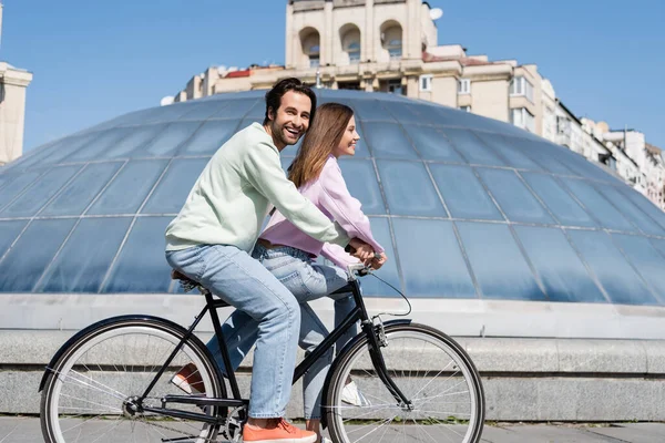 Χαμογελώντας Άνθρωπος Κοιτάζοντας Κάμερα Ενώ Ποδηλασία Φίλη Στο Αστικό Δρόμο — Φωτογραφία Αρχείου
