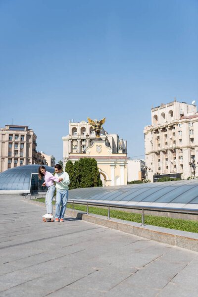 КИЕВ, УКРАИНА - 1 СЕНТЯБРЯ 2021: Улыбающаяся пара на доске для верховой езды на городской улице, Майдан Независимости