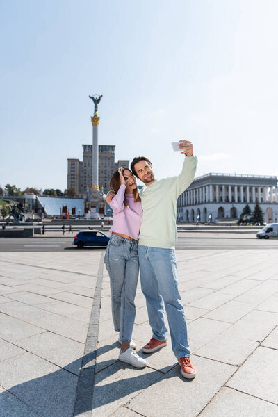 КИЕВ, УКРАИНА - 1 СЕНТЯБРЯ 2021: Улыбающаяся пара делает селфи на мобильном телефоне на Площади Независимости в Киеве