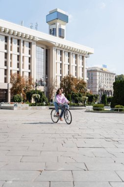 Şehrin göbeğinde bisiklet süren genç bir çift. 