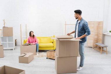 Neşeli kadın, Arap erkek arkadaşının yanında kitap ve paketleri tutuyor. 