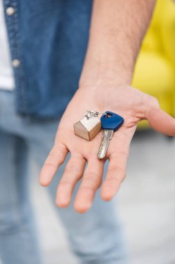 Cropped view of key on hand of blurred man at home 