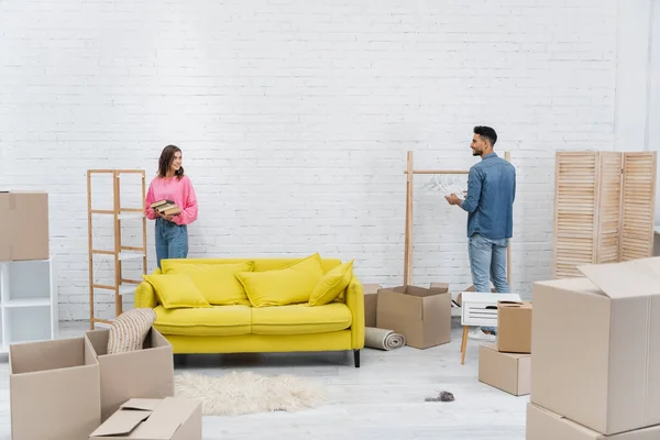 Cheerful Multiethnic Couple Unpacking Carton Boxes Living Room — Stok fotoğraf