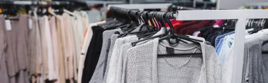 Clothing on hangers on rack in vintage shop, banner 