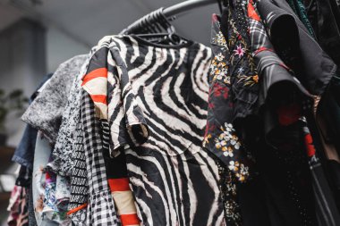 Low angle view of vintage blouses on hangers in vintage shop 