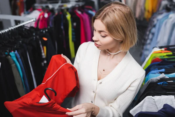 Visão Alto Ângulo Jovem Mulher Loira Olhando Para Roupas Perto — Fotografia de Stock