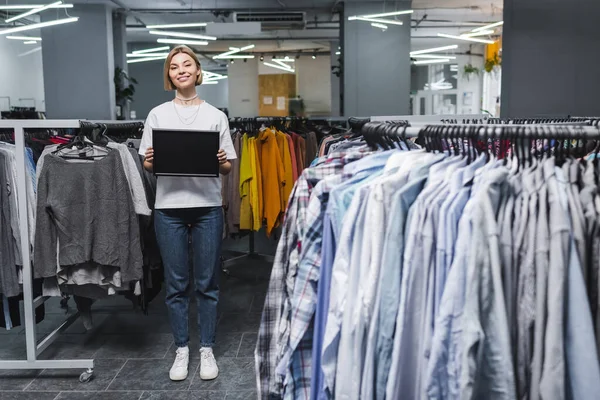 Smiling Saleswoman Holding Empty Board Clothes Second Hand — Φωτογραφία Αρχείου