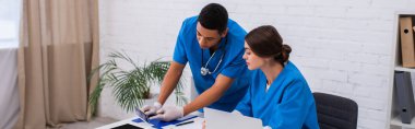 Afrika kökenli Amerikalı veteriner meslektaşı ve klinikteki cihazların ultrason taramasına işaret ediyor. 