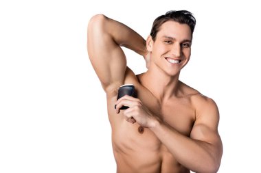Mutlu gömleksiz adam beyaz koltukaltına deodorant sürüyor.