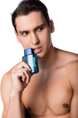 man with bare chest holding vial of perfume and looking away isolated on white clipart