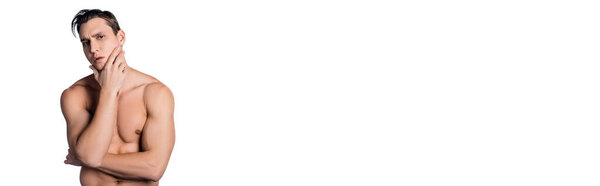 вдумчивый мужчина без рубашки касаясь лица и глядя на камеру изолированы на белом, баннер
