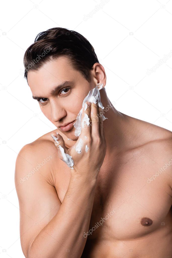 man with naked chest applying shaving foam and looking at camera isolated on white