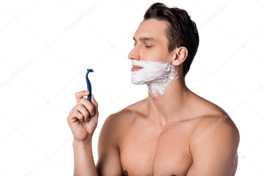 shirtless man with shaving foam on face holding safety razor isolated on white