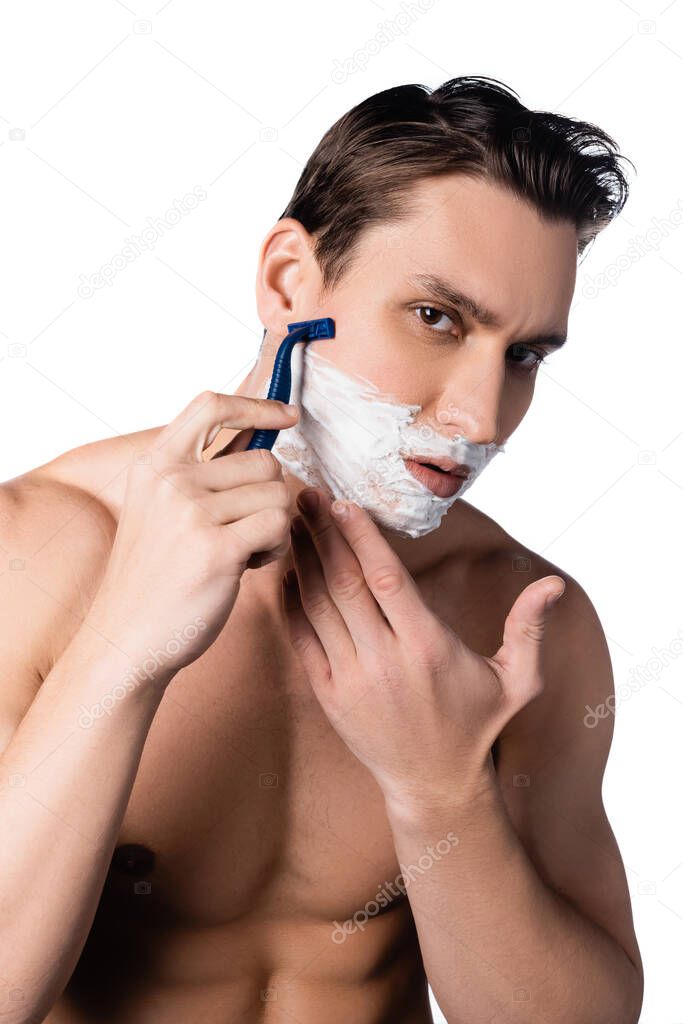 shirtless man with bare chest looking at camera and shaving isolated on white