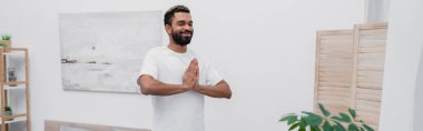 Afro-amerikan mutlu adamı Afro-amerikalı adam dua eden elleriyle ekranın yanında meditasyon yapıyor, pankart