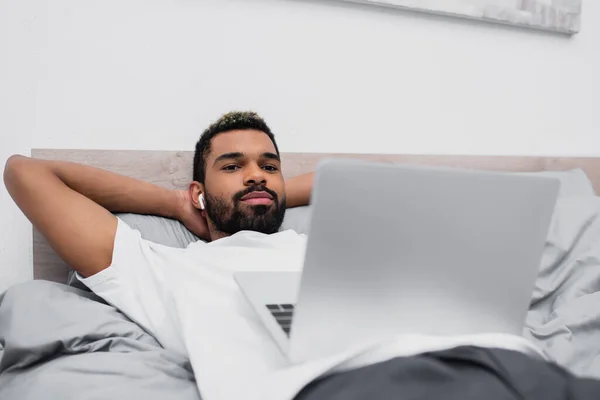 African American Man Wireless Earphones Watching Movie While Lying Bed — Stock Photo, Image