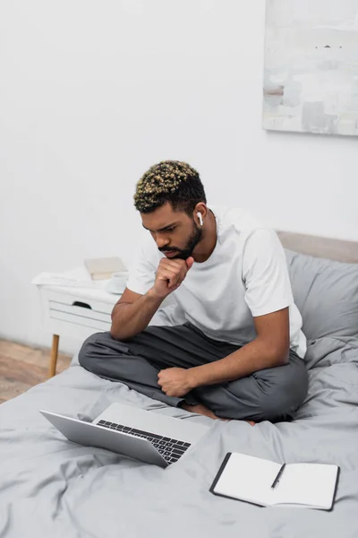 Thoughtful African American Man Wireless Earphone Using Laptop Working Home — Stock Photo, Image